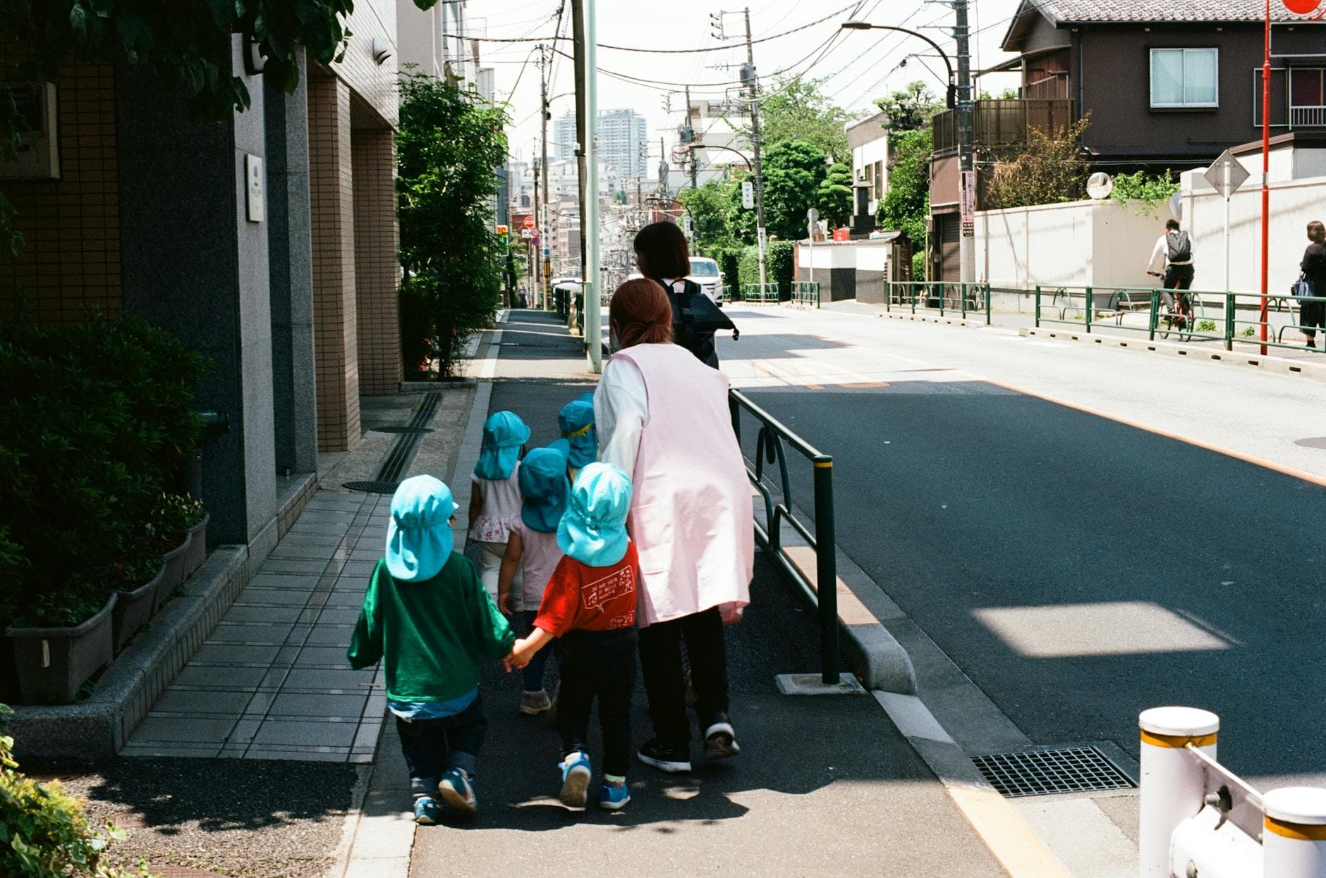 Toddlers walking on a school path with their teachers