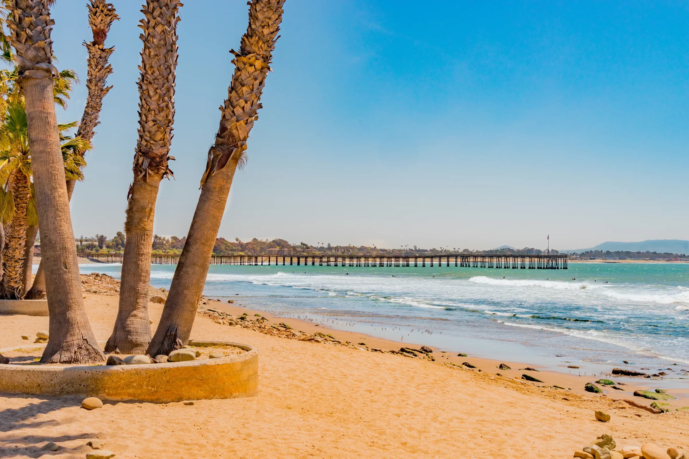 Ventura Pier framed by palms, Pacific behind, coastal mountains in the distance